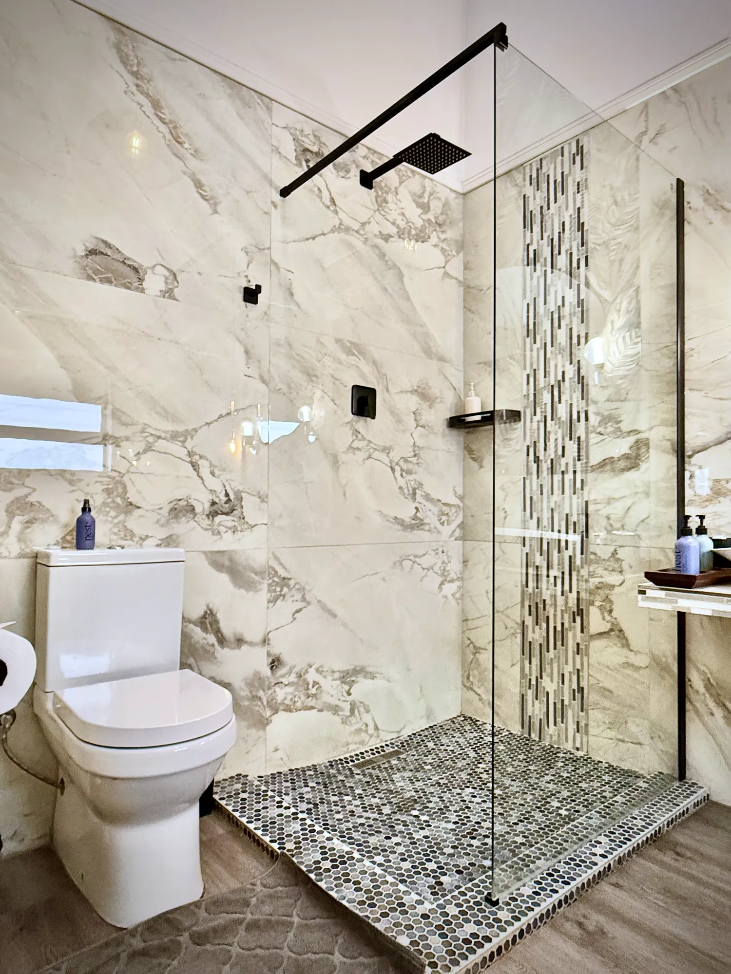 Birch Luxury Studio walk-in shower with marble tiles and a pebble floor