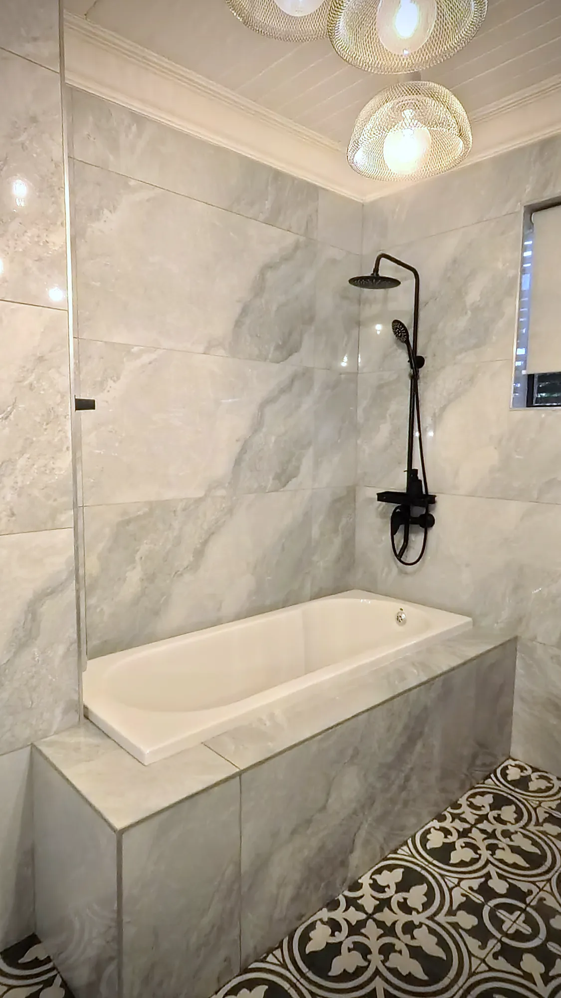 Cedar Luxury Studio bath with marble-look tiles