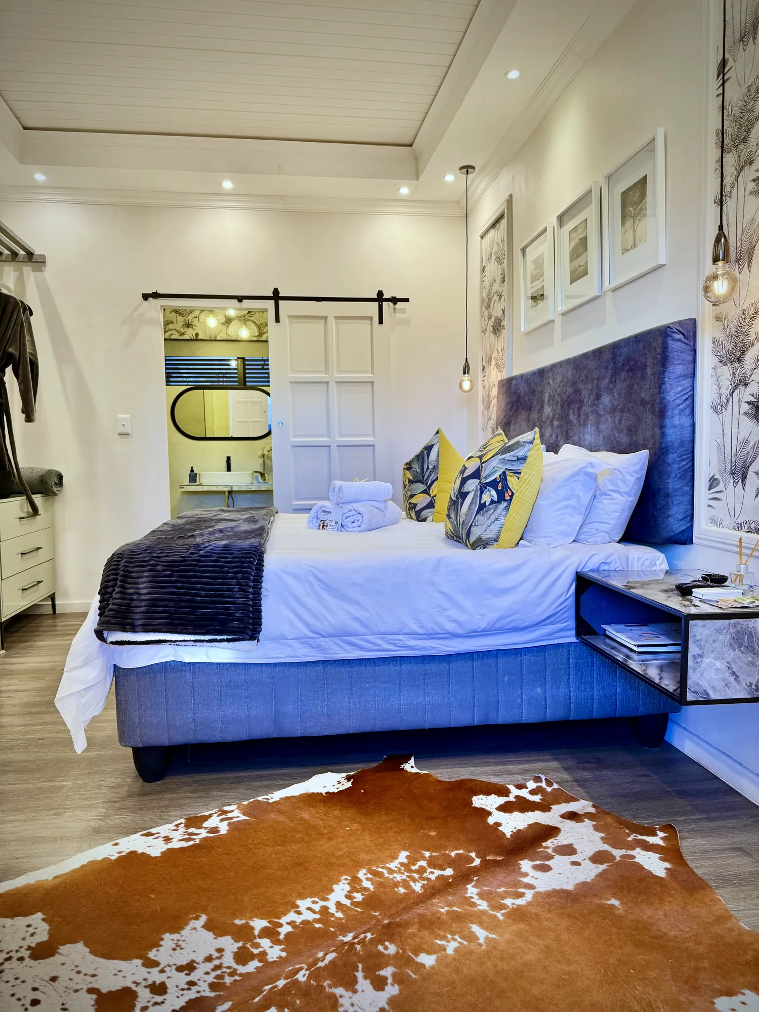 Cedar Luxury Studio: navy velvet headboard, white linen and a cowhide rug