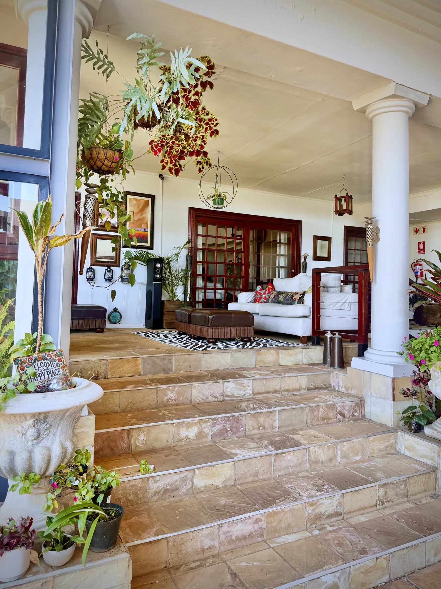 Courtyard steps leading to the lounge, with pillars and potted plants