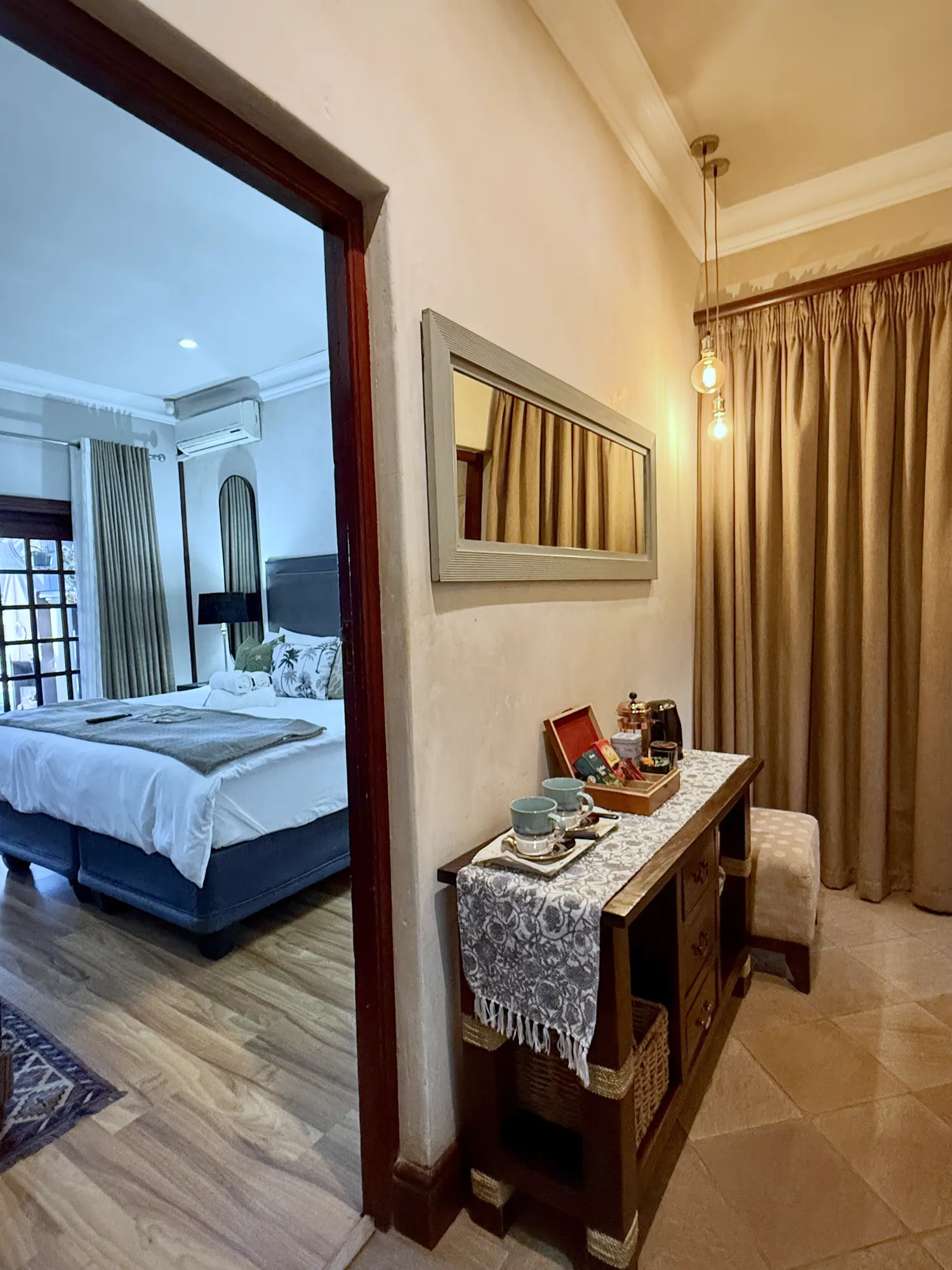 Luxury East Suite coffee station and mirror, with the bedroom beyond