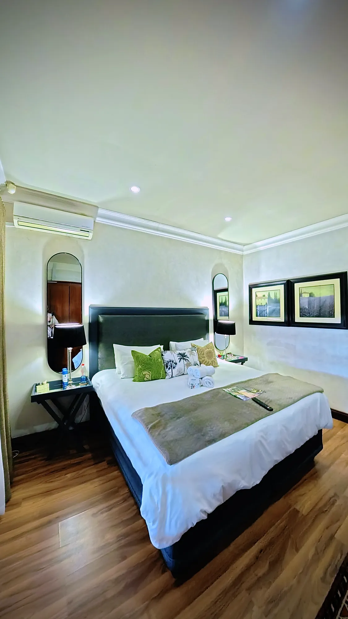 Luxury East Suite bedroom with bedside lamps and an arched mirror