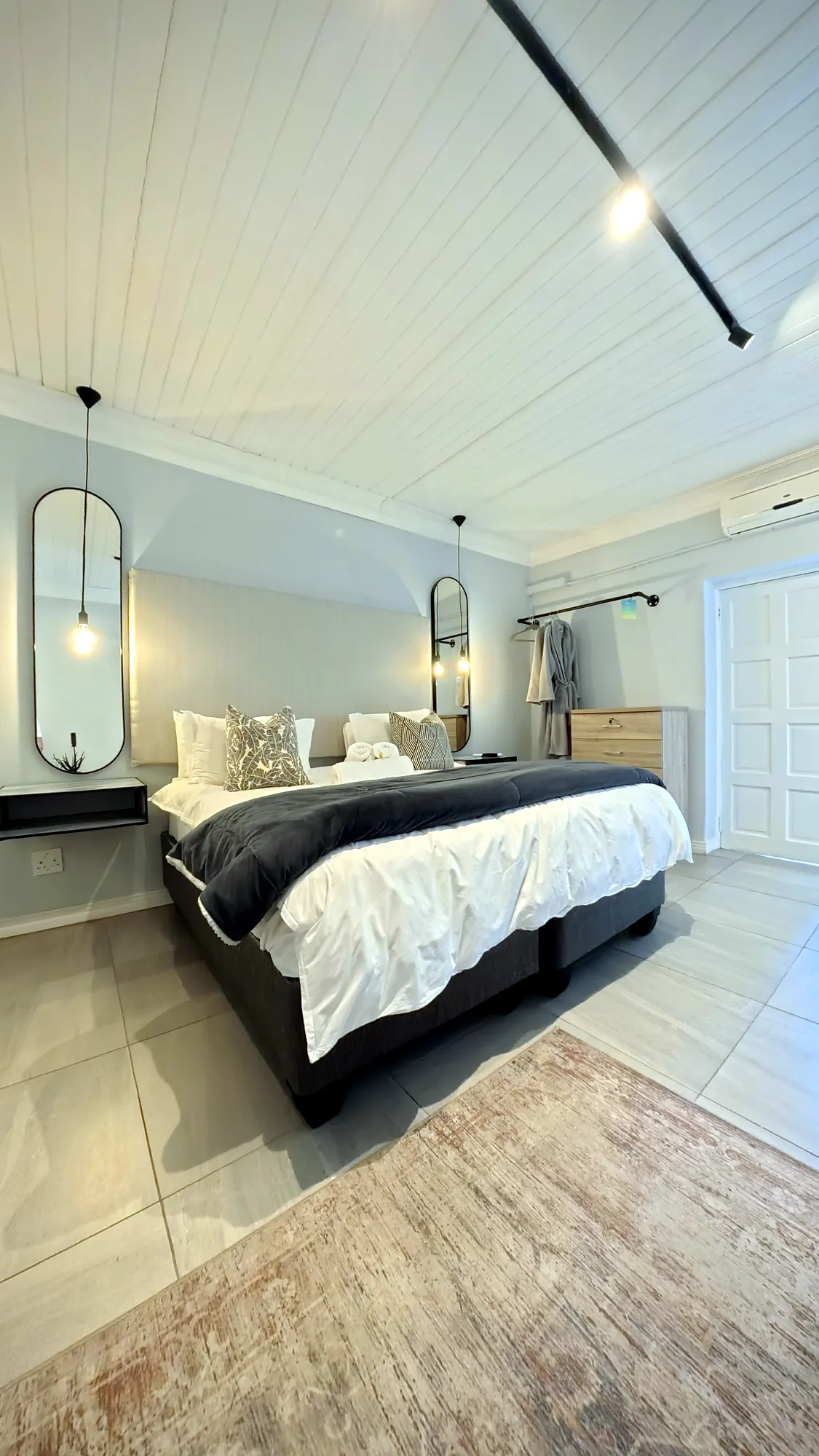 The bed and mirror in the Oak Luxury Studio