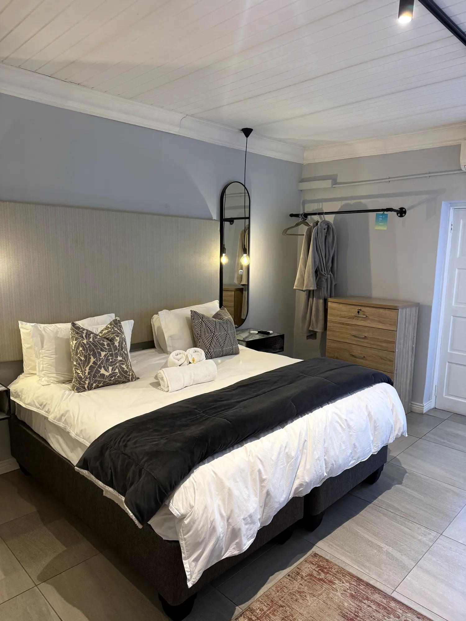 Oak Luxury Studio: king-size bed with grey linen throw, wooden dresser and track lighting